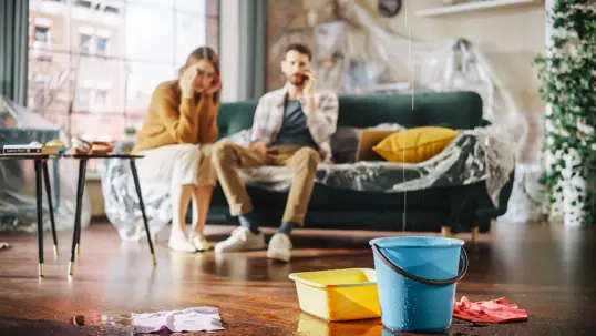 couple stressed by indoor ceiling leak